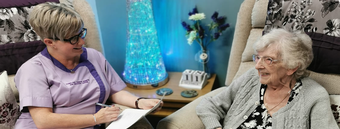 A Town & Country carer chatting and laughing with a resident
