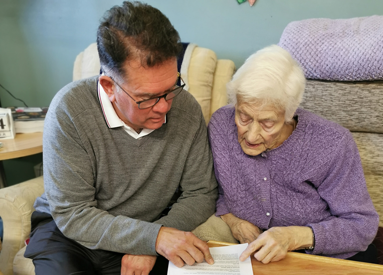 A Town & Country carer reading together with a client at home